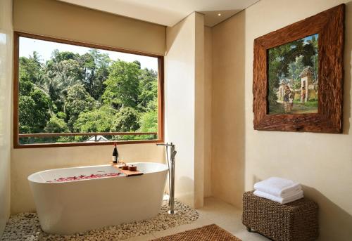 德格拉朗Cicada Luxury Resort - Ubud的带浴缸的浴室和大窗户