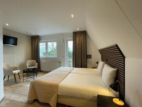 东卡佩勒兰杜因酒店的一间带大床的卧室和一间客厅
