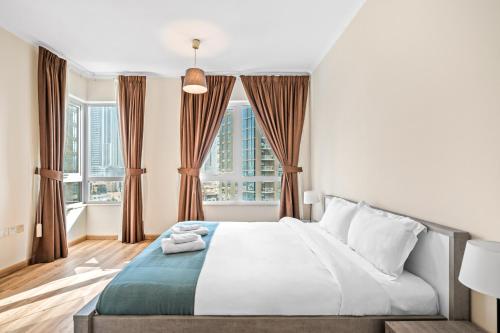 迪拜Fountainview Luxe 1BR, sleeps 4的一间卧室设有一张床和两个窗户。