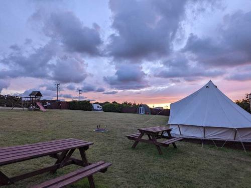 特鲁罗Penhallow Glampsite的野外两张野餐桌和白色帐篷