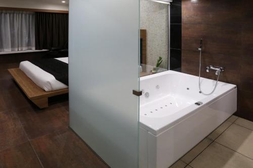 奥兰加巴德大凯拉什酒店 的带浴缸的浴室和卧室