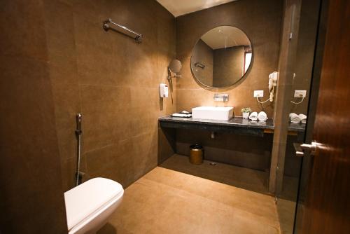 阿格拉Dazzling的一间带卫生间、水槽和镜子的浴室
