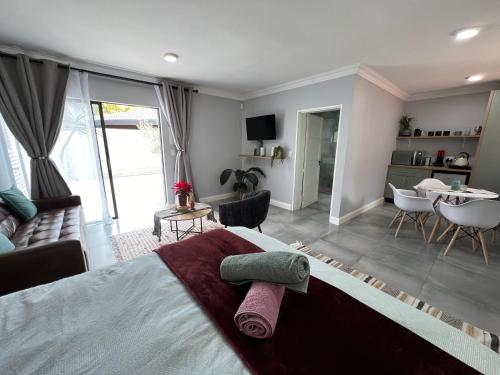 比勒陀利亚Afrique134 Olive Tree Private Courtyard Suite的一间卧室设有一张床和一间客厅。