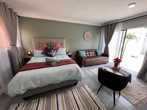 比勒陀利亚Afrique134 Olive Tree Private Courtyard Suite的一间卧室配有一张床、一把椅子和一张沙发