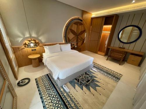 利雅德Aseel Resort的卧室配有白色的床和镜子