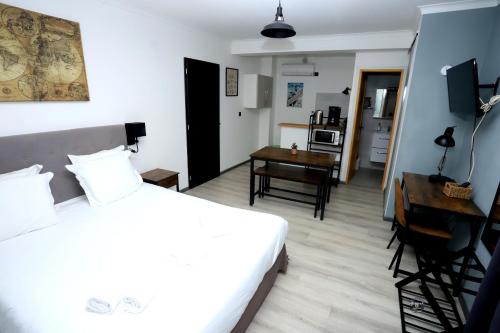 科尔特Apparts' hôtel Casa di a Restonica的一间带一张床和一张书桌的卧室和一间厨房