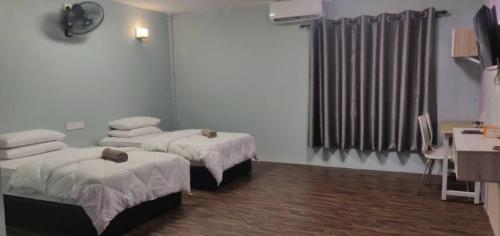 瓜拉弄宾Tazrah roomstay (1 queen or 2 twin super single room)的一间医院间,配有两张床和电视
