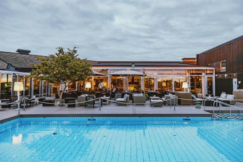 图勒科夫图勒科夫酒店的一座带椅子的游泳池以及一座建筑