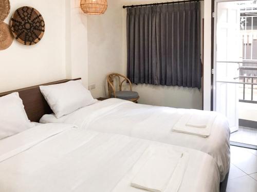 清迈บ้านสวนอินทาวน์ Baansuan in Town Hotel的一间卧室设有两张白色的床和窗户