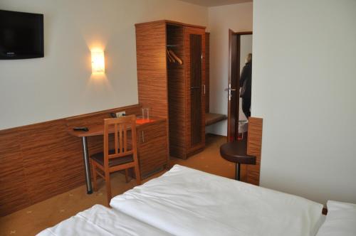 Sankt Andrä bei Frauenkirchen祖尔林德酒店的一间卧室配有一张床、一张桌子和一张书桌