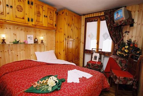 瓦托内切B&B Lepetitnid的一间卧室配有红色的床和电视