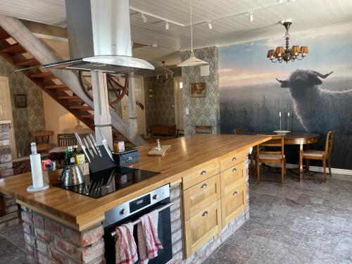 克里斯蒂娜港Åkerbo gård charmigt renoverad flygel的厨房配有柜台和带羊壁画的桌子