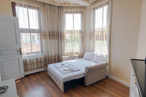 伊斯坦布尔IQ Hotel Galatasaray的一间卧室配有一张床、一张沙发和窗户。