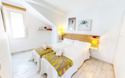 德尼亚Apartamento Net by Family Homes的白色的卧室设有床和窗户