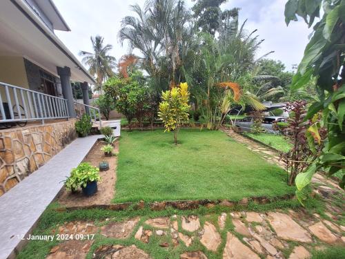 ManyemaFour bedroom home in Dar es salaam at Salasala near Mbezi beach的后院,有一片草地和树木