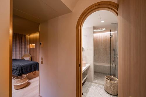 巴黎Hôtel Madison的客房设有带淋浴的浴室和卧室。