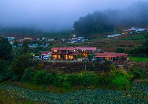 乌提Silent Valley Farm Resort Ooty by VOYE HOMES的山上的一座房屋,灯光照亮