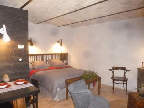 RottierFONT DE RAINE的一间卧室配有一张床、一把椅子和一张桌子