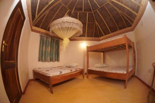 姆特瓦拉AFLII Beach Club ( Zanzibar Beach )的配有木天花板的客房内的两张双层床