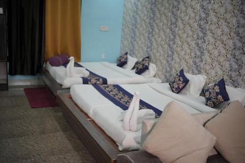 瑞诗凯诗Panambi Tapovan Resort的排在房间里的一排床