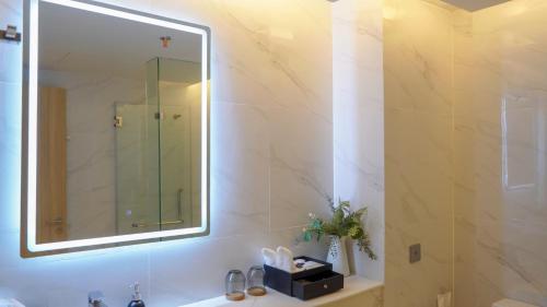 曼谷Shenzhen Tower Hotel Thonglor Sukhumvit的一间带大镜子和盥洗盆的浴室