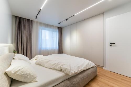 阿拉德Kuib Central Apartament的卧室配有白色的床和窗户。