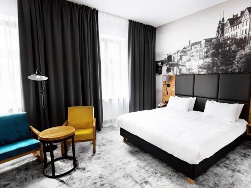 奥普尔奥波莱美居酒店的配有一张床和一把椅子的酒店客房