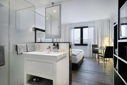 汉堡INNSiDE by Meliá Hamburg Hafen的白色的浴室设有水槽和一张床