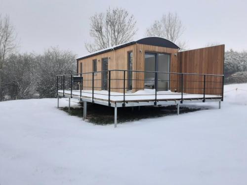 HamoisAu p'tit pré des salers的雪中带甲板的小房子