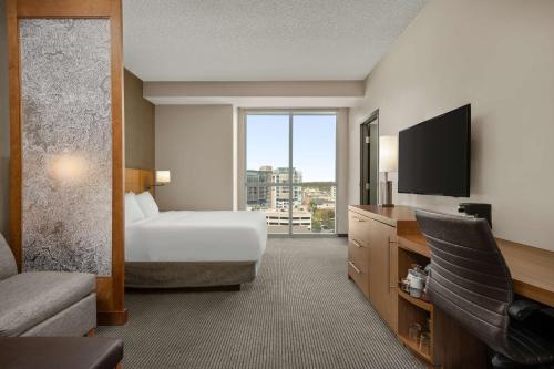 爱荷华Hyatt Place Iowa City Downtown的配有一张床和一台平面电视的酒店客房