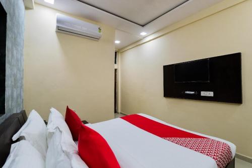 NarodaHotel Sunrise的卧室配有一张床铺,墙上配有电视