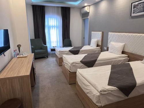 巴库Jupiter的酒店客房设有三张床和电视。