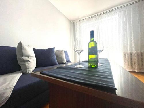 索斯诺维茨MIESZKANIE W IDEALNEJ LOKALIZACJI的一瓶葡萄酒和一张桌子上的一杯