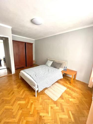 索斯诺维茨MIESZKANIE W IDEALNEJ LOKALIZACJI的一间卧室配有一张床,铺有木地板
