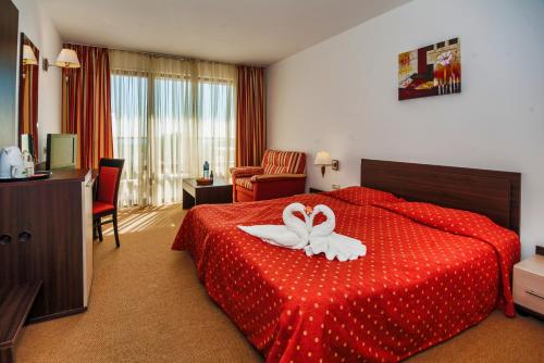 茨雷沃Hermes Club Hotel - Ultra All Inclusive的一间酒店客房,配有红色的床,上面有花