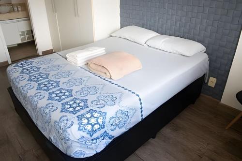 里约热内卢Loft Executivo - Ideal para família.的一张带蓝色和白色毯子及枕头的床