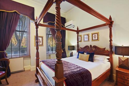 伦敦二十内文广场酒店的一间卧室配有四柱天蓬床