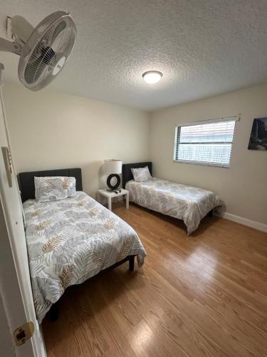 克利尔沃特Delightful 3 Bdrm Home, Mins to Clearwater Beach的一间卧室配有两张床和风扇