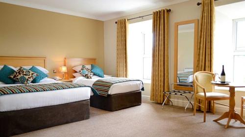 基尔特马Cill Aodain Court Hotel的酒店客房配有两张床和一张书桌