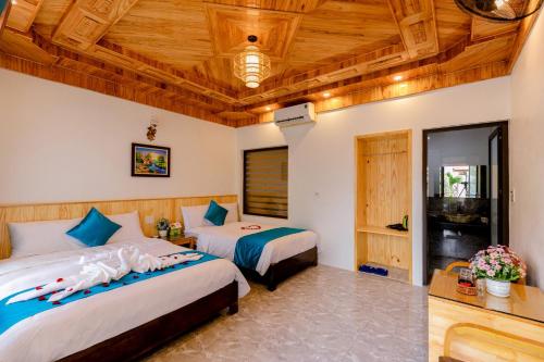 宁平Tam Coc Green Mountain Homestay的一间卧室设有两张床和木制天花板