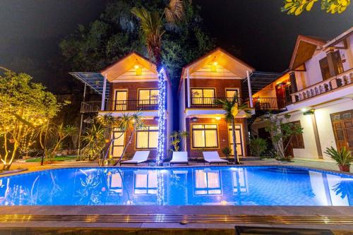 宁平Tam Coc Green Mountain Homestay的夜间在房子前面的游泳池