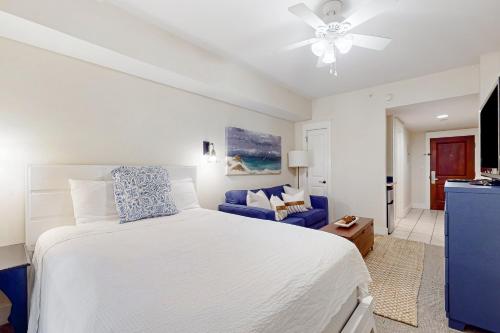 德斯坦Baytowne Wharf - Pilot House #207的卧室配有白色的床和蓝色的沙发