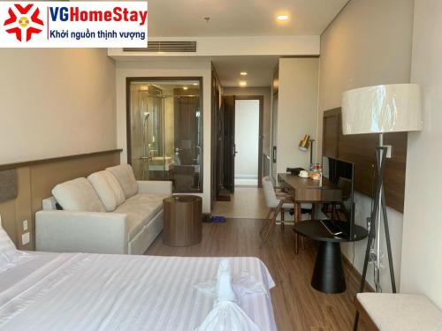 海阳Apec Mandala hotel & suites Hải Dương的客房设有床、沙发和桌子。