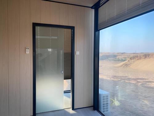 迪拜Sahara INN Smart Resort & Camping的通往享有沙漠景致的客房的开放式门