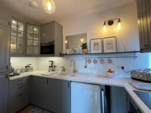 梅尔罗斯Bijou apartment in the heart of Melrose的厨房配有白色的柜台和白色的橱柜