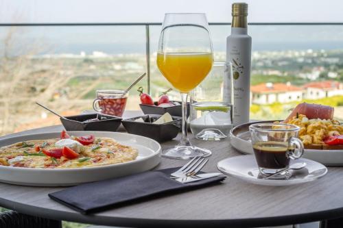 KórinthosACRO Upscale Residences的一张桌子,上面放着一盘食物和一杯葡萄酒