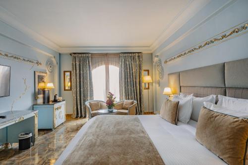 马拉喀什Grand Mogador Menara & Spa的一间设有大床和窗户的酒店客房
