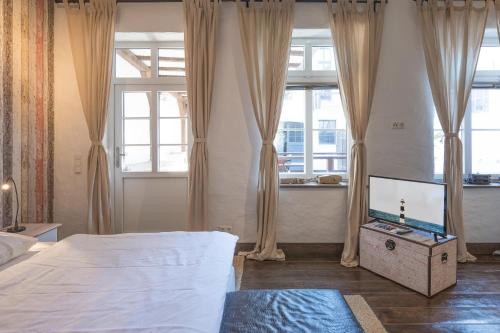 胡苏姆Lodge am Oxenweg - Zimmer 2的一间卧室配有一张床和一台平面电视