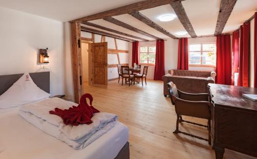 乌尔丁根-米赫尔霍芬Bodensee Hotel Storchen的一间卧室配有一张红色带子的床