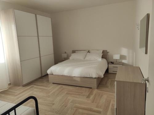 奥梅尼亚Residenza Gattoni CIR 10305000162 Omegna Lago d'Orta的一间铺有木地板的白色卧室,配有一张床